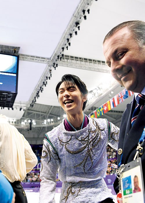 コーチのブライアン・オーサー（左）、ジスラン・ブリアン（右）と喜びを分かちあう羽生