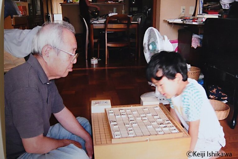 幼い頃の藤井聡太竜王が祖父と将棋をする姿　※写真を複写（写真は右に続きます）　©Keiji Ishikawa